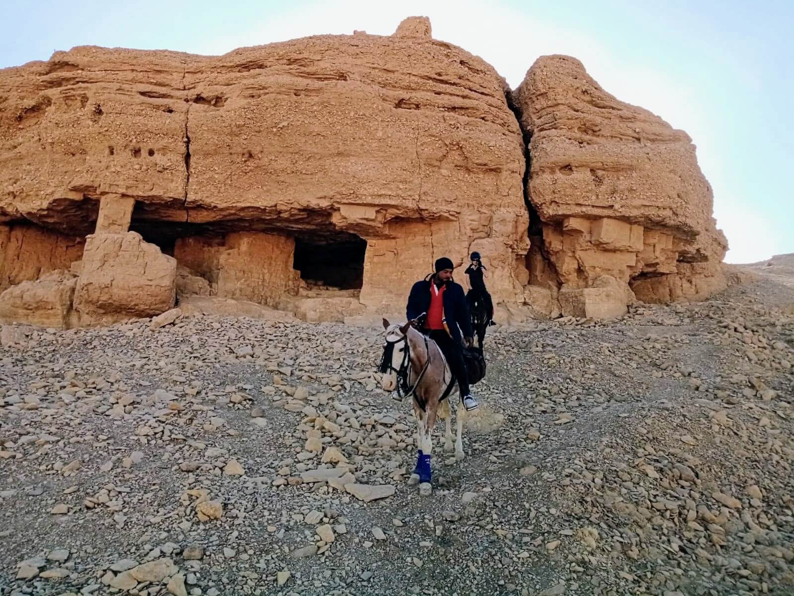 horse-riding-in-front-of-desert-rock-caves-luxor-egypt